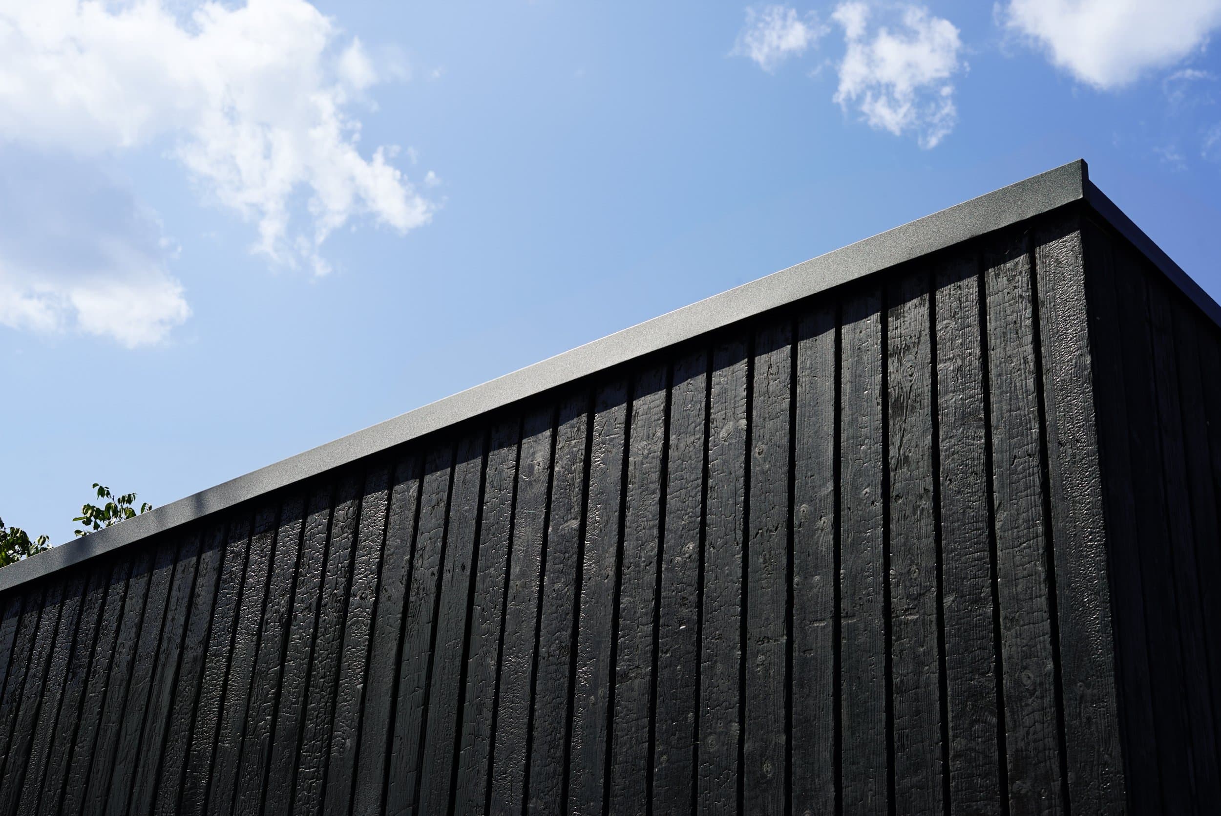 Roof and wall corner with charred timber cladding